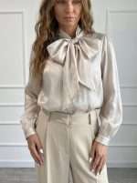 La Camicia Mussola di Operà Fashion è un capo sofisticato che conquista per il suo importante fiocco sul collo e il tessuto luminoso dall'effetto satinato. Le linee morbide e la vestibilità elegante la rendono perfetta sia per occasioni formali che per look ricercati da giorno. Abbinata a pantaloni sartoriali o gonne eleganti, dona un'eleganza senza tempo ad ogni outfit.